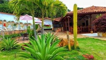 A patio area with outdoor seating, a covered dining area, and a variety of plants.