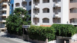 Un edificio de hotel de varios pisos con balcones, unidades de aire acondicionado y un letrero que indica el nombre 'HOTEL ANITA'.