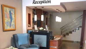 Zona de recepción con mostrador, asientos y una escalera.