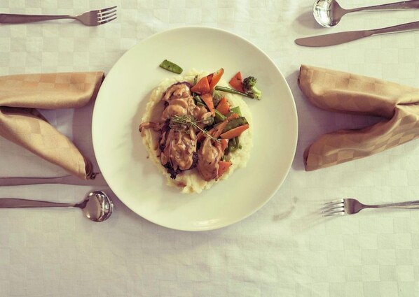 A plate of food with a fork and spoon on a tablecloth. - Light Villas (Nairobi)