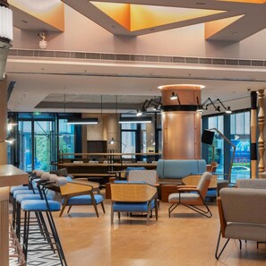 A modern interior with seating areas, a central column, and large windows. - Guangzhou Zengcheng Tongpai Hotel (Guangzhou)