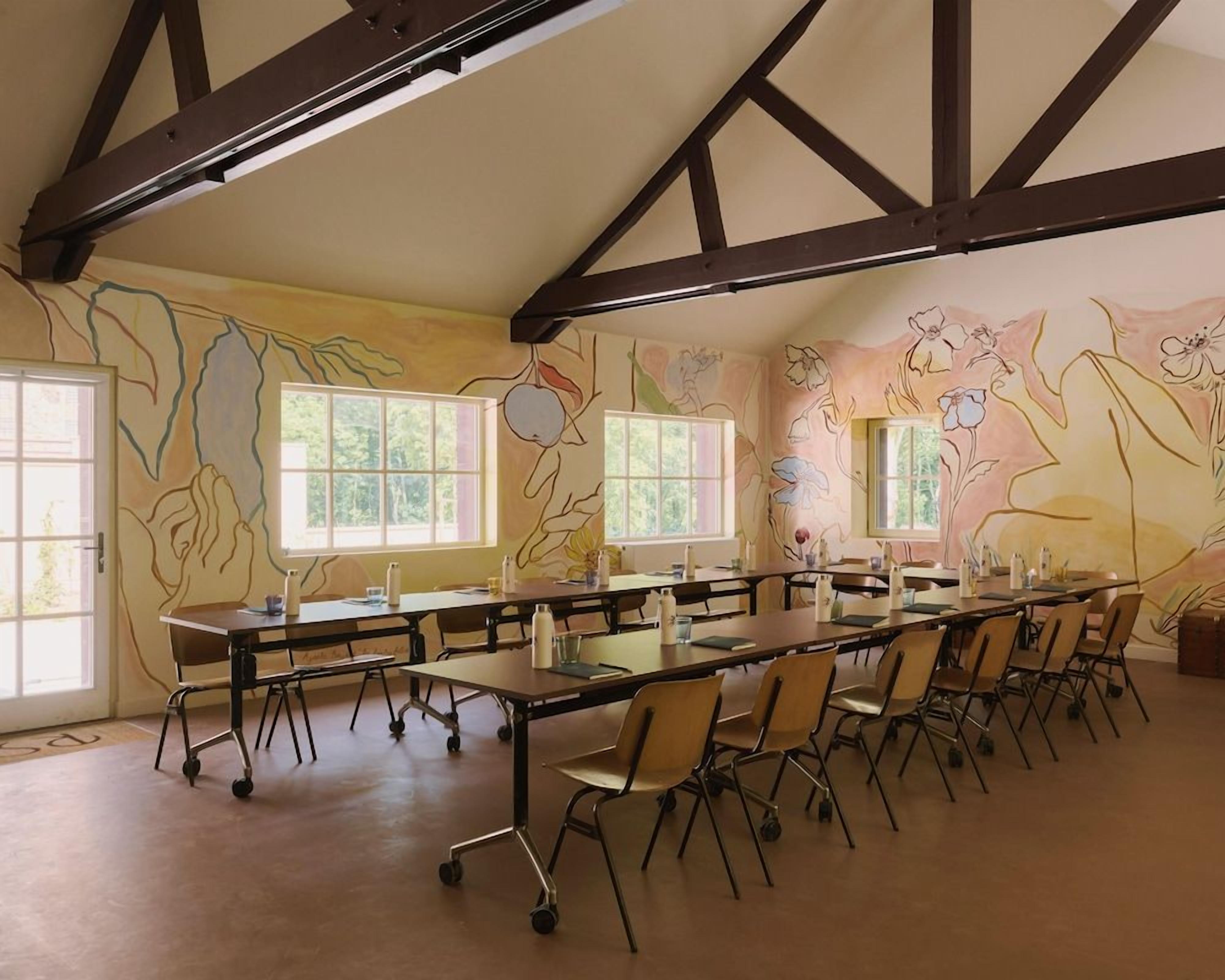 A conference room with a long table, chairs, and large windows.