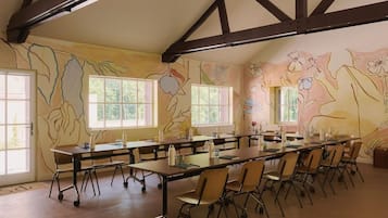 A conference room with a long table, chairs, and large windows.