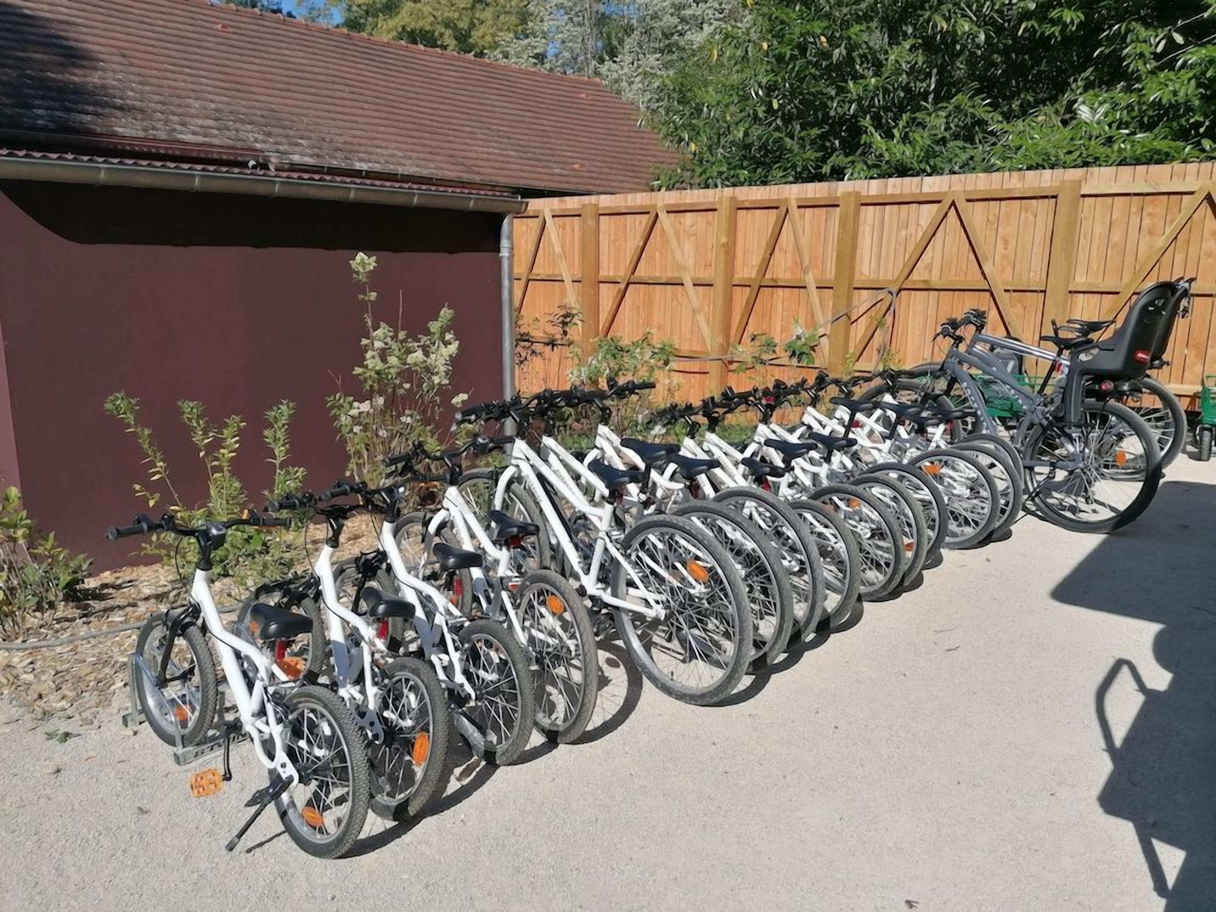 Una fila de bicicletas estacionadas junto a una valla de madera.