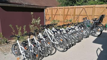 Una fila de bicicletas estacionadas junto a una valla de madera.