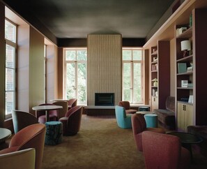 Una biblioteca con chimenea, estanterías y un mobiliario cómodo.