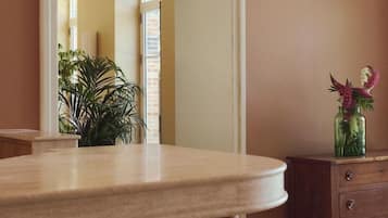 A bathroom with a round vanity, a mirror, a wooden cabinet, and a potted plant.