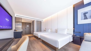 Una habitación de hotel moderna con una cama grande, un escritorio y un televisor.