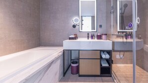 Un baño moderno con bañera, tocador con espejo y zona de ducha.