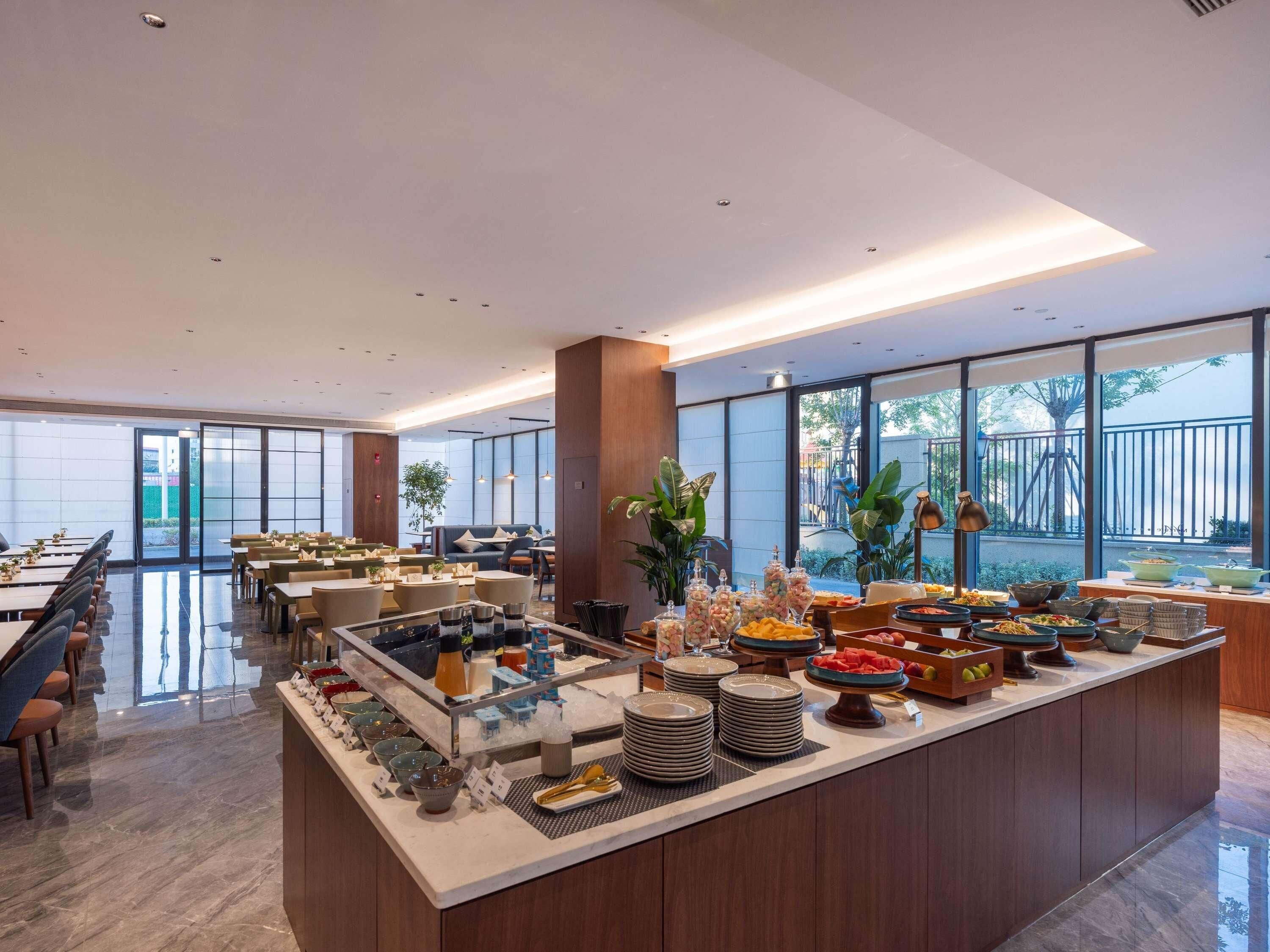 A modern dining area with a buffet setup, including various food items and a seating arrangement.