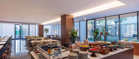 Een moderne eetruimte met een buffet, diverse gerechten en een zithoek.