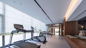 Un gimnasio moderno con cintas de correr, bicicletas estáticas y máquinas de pesas.