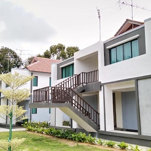 A modern residential building with a staircase leading to a balcony, surrounded by greenery. - Bayu Balau Beach Resort (Bandar Penawar)