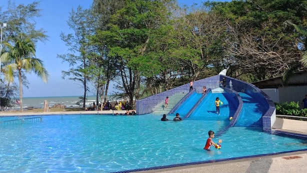 Piscina com escorrega e vista para a praia.