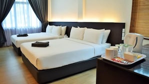 Quarto de hotel com duas camas, uma mesinha de cabeceira com uma bandeja de itens de café da manhã e uma janela com cortinas.