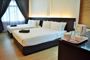 A hotel room with two beds, a bedside table with a tray of breakfast items, and a window with curtains. - Bayu Balau Beach Resort (Bandar Penawar)
