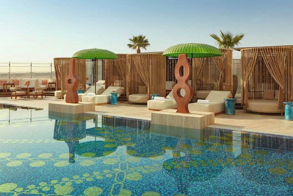A poolside lounge area with seating and umbrellas. - W Riyadh Kafd (Riyadh)