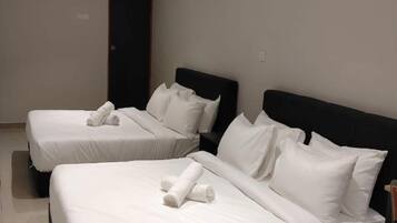 A hotel room with two beds, each with white linens and pillows, a dark headboard, and an air conditioning unit on the wall.