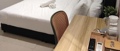 Une chambre d’hôtel avec deux lits, un bureau, une chaise, une télévision et un appareil de climatisation.