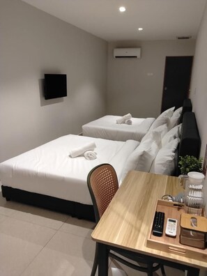A hotel room with two beds, a desk, a chair, a TV, and an air conditioning unit. - Swing & Pillows AT Bukit Tinggi Klang (Klang)