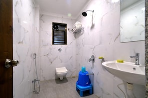 A bathroom with a toilet, a shower, a sink, and a mirror. - Hotel Dwarka Park (Rahata)