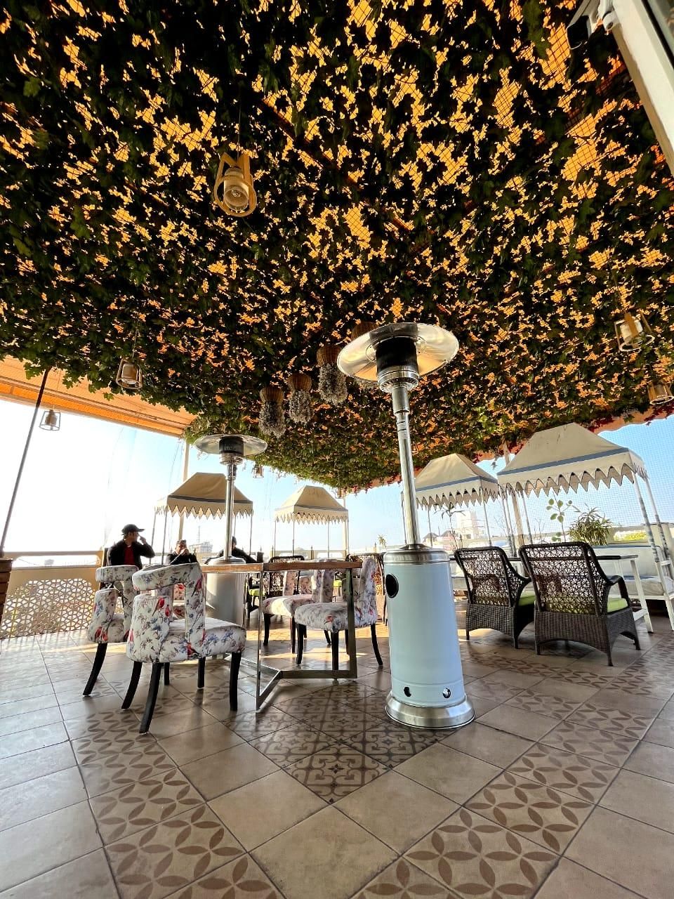 Un área de estar al aire libre con baldosas estampadas, una columna central y un techo decorativo.