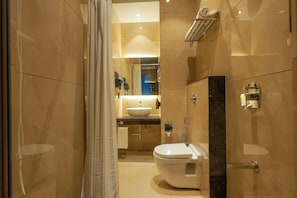 Un baño moderno con inodoro, lavamanos y zona de ducha.
