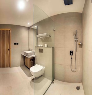 A modern bathroom with a glass-enclosed shower, a wooden vanity, and a toilet. - Comfort Inn Grand (Ghaziabad)