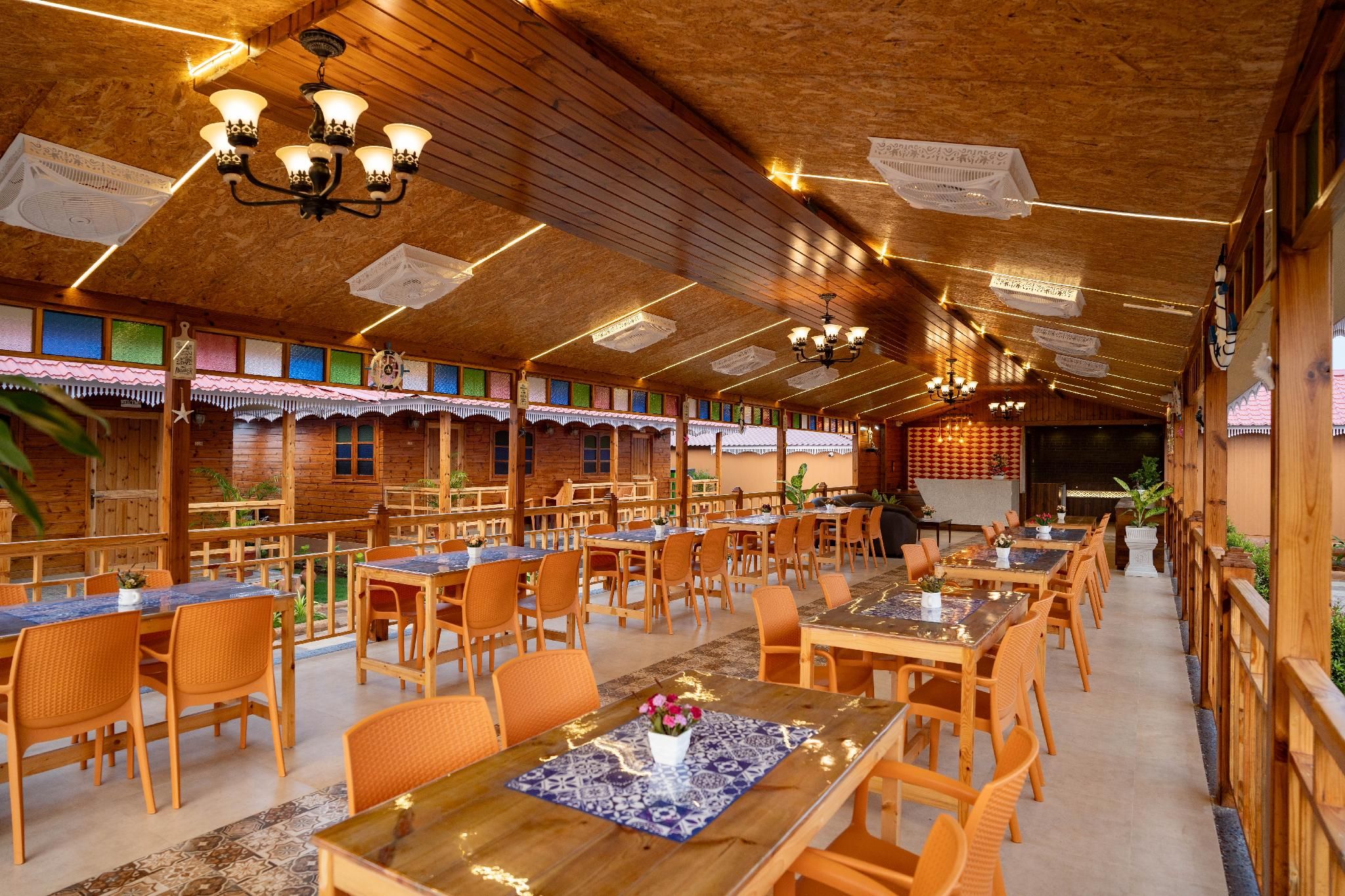 Un restaurant dont l’intérieur est décoré de bois, avec de nombreuses tables et des chaises.
