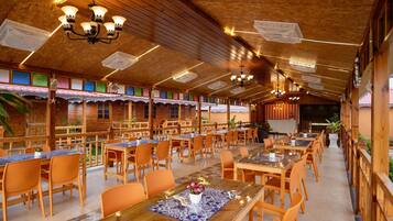 Un restaurant dont l’intérieur est décoré de bois, avec de nombreuses tables et des chaises.