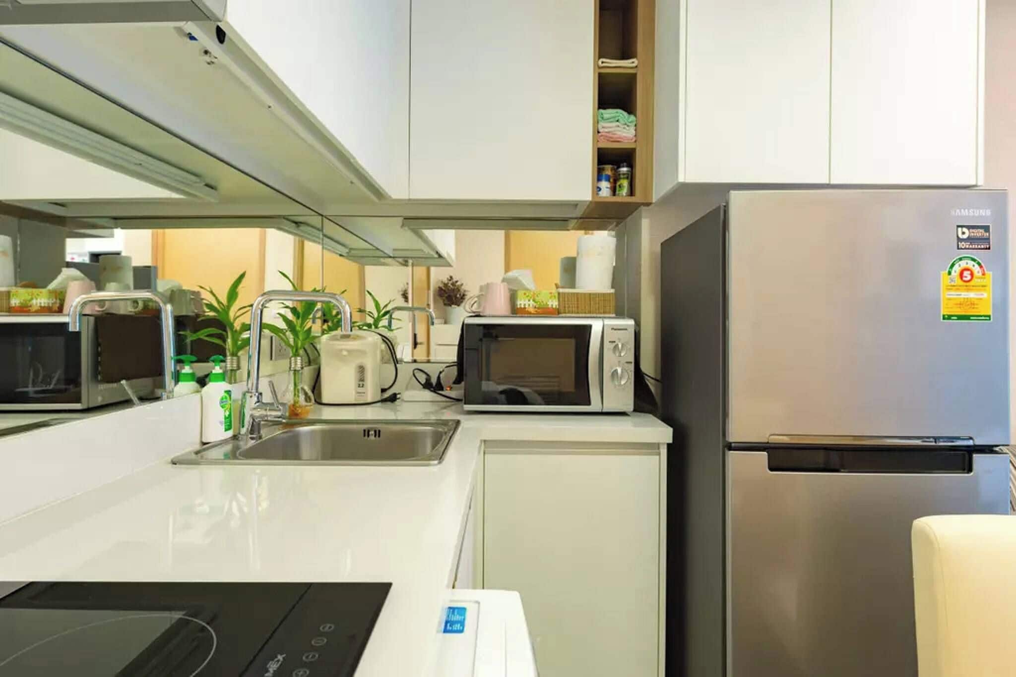 A modern kitchen with stainless steel appliances, including a refrigerator, microwave, and toaster.