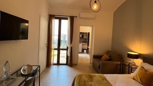 A hotel room with a bed, a desk, a chair, a TV, and a lamp. - MARMORE GREEWAY (Collestatte Piano)