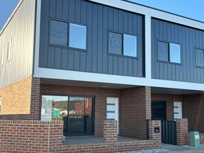 A modern two-story building with a brick facade and large windows.