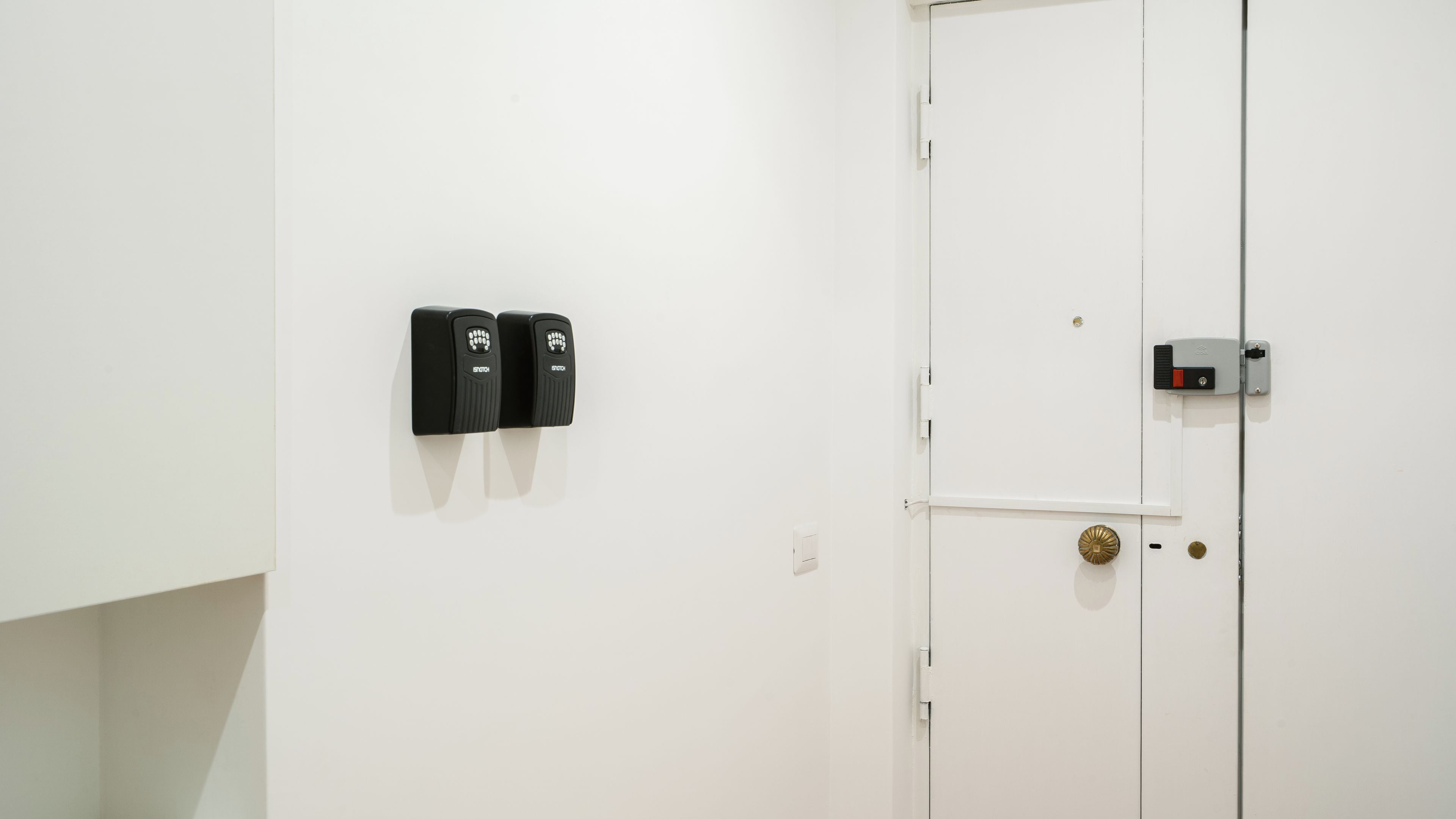A white door with a keyhole and a doorbell.