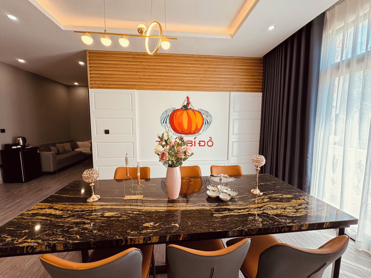 A modern dining area with a marble table, chairs, and a decorative centerpiece.