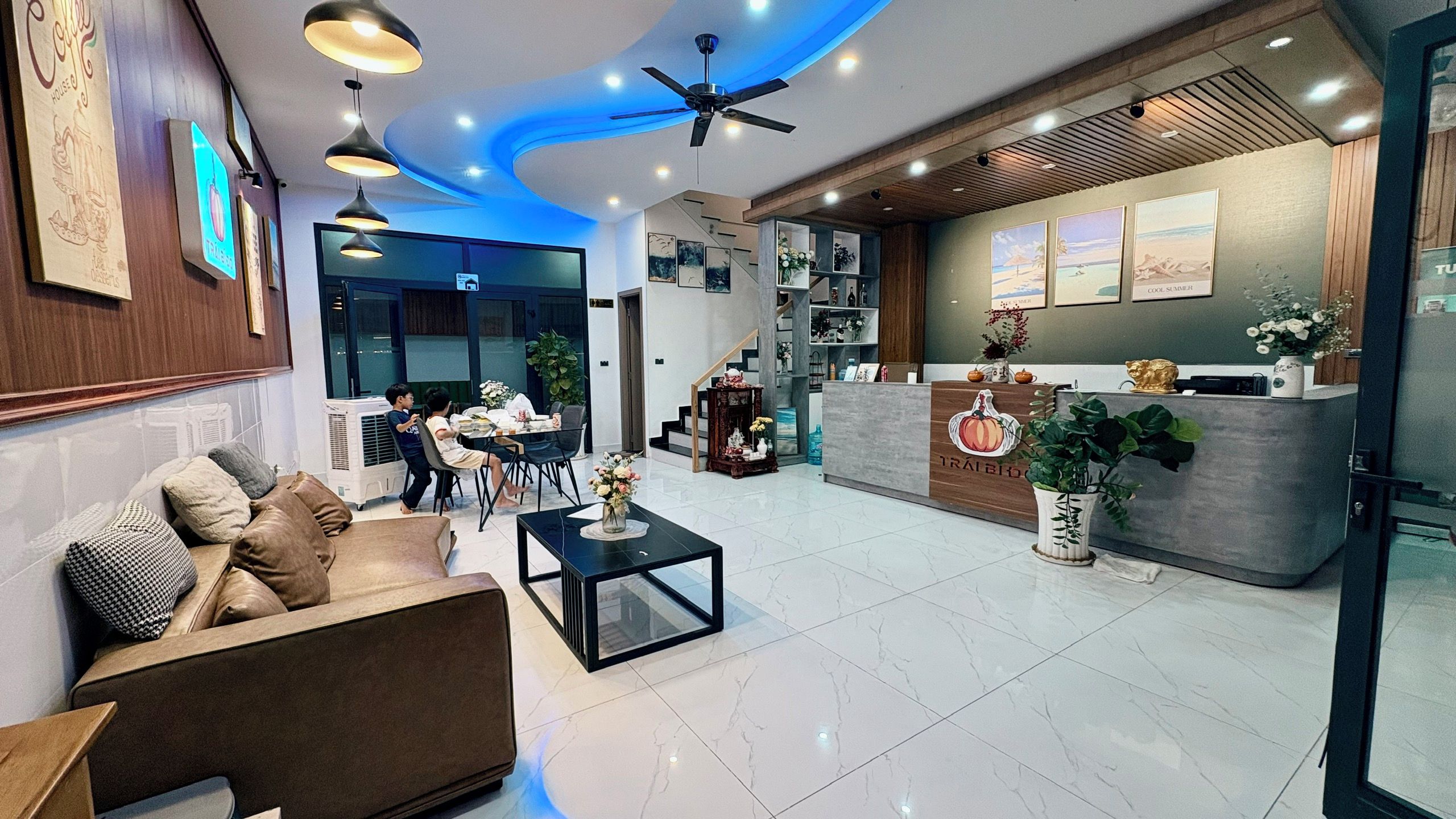 A hotel lobby with a reception desk, seating area, and a staircase.