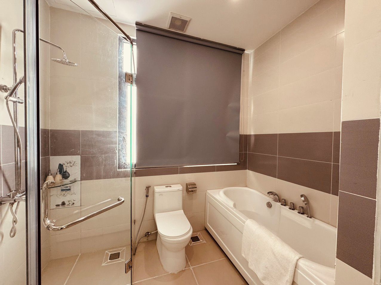 A bathroom with a shower, toilet, and bathtub.