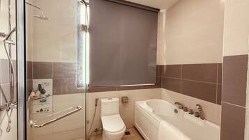 A bathroom with a shower, toilet, and bathtub.