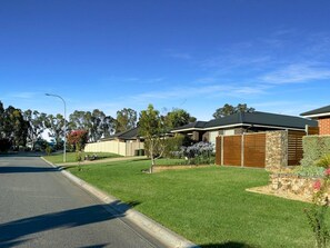 A residential street with houses, a clear sky, and a well-maintained lawn. - St Pauls Comfort Home (Wagga Wagga)