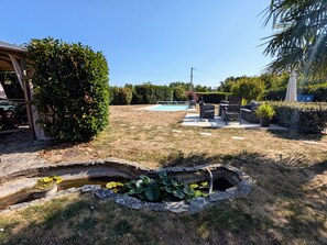 A backyard with a swimming pool, outdoor furniture, and a small garden area. - Duplex studio with shared pool - 2 guests (Argenton-sur-Creuse)