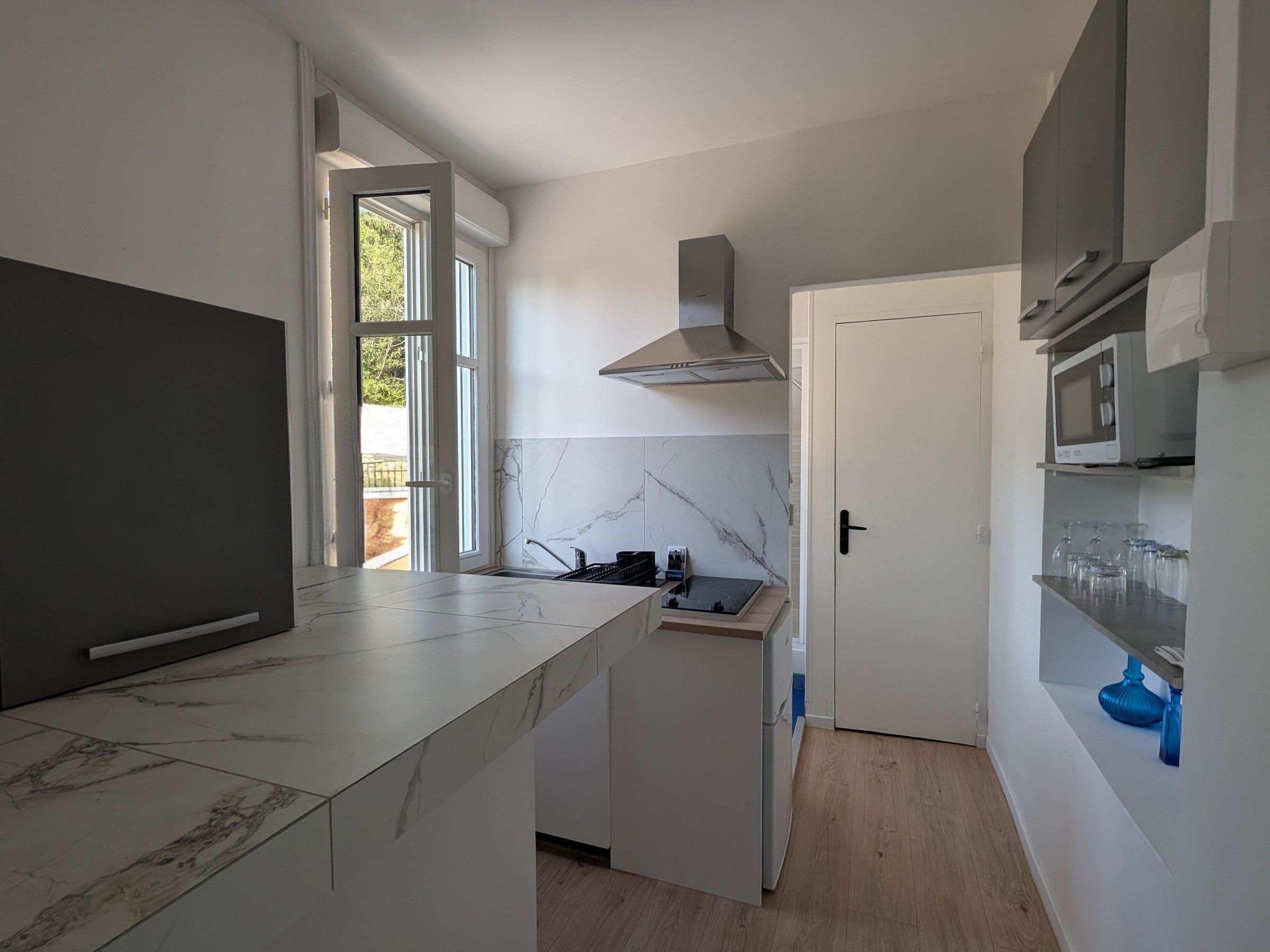 Et moderne køkken med en stor ø, indbygget mikroovn og komfur.