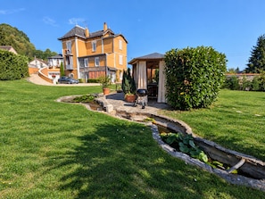 A two-story house with a paved driveway, a small garden with a pond, and a barbecue area. - Studio with pool, shared garden - 2 guests (Argenton-sur-Creuse)