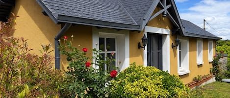 A house with a gabled roof, a front porch, and a well-maintained garden.