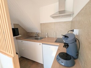A compact kitchen with a sink, a dishwasher, a coffee machine, and a small refrigerator. - Charming studio in Val de Creuse (Argenton-sur-Creuse)