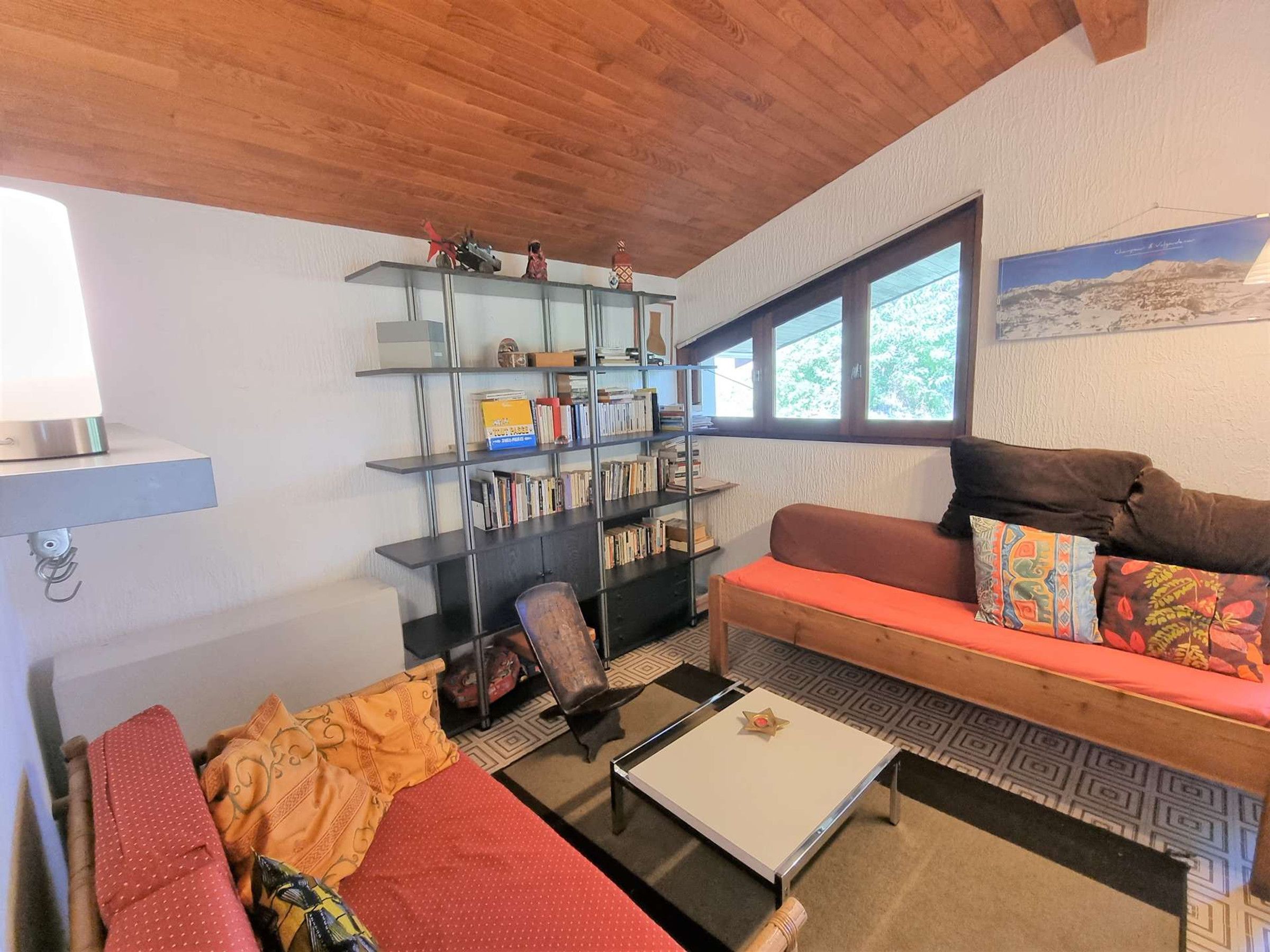 Un salón acogedor con sofá, mesa de centro y estantería.