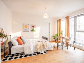 Ein modernes Schlafzimmer mit Bett, Nachttisch und einem Fenster mit Vorhängen.
