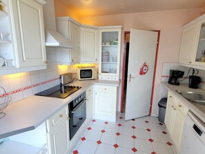 A compact kitchen with white cabinets, a microwave, a toaster, and a coffee maker.