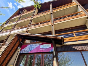 A multi-story building with balconies, a sign for 'La Lozzière,' and a website address.