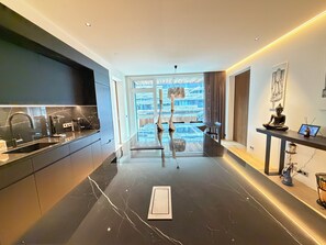 A modern kitchen with a black marble countertop, a built-in stove, and a large window with a view of the cityscape. - Luxary apartment in downtown Reykjavik (Reykjavík)