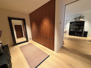 A modern interior with a wooden wardrobe, a large mirror, and a wooden floor. - Luxary apartment in downtown Reykjavik (Reykjavík)